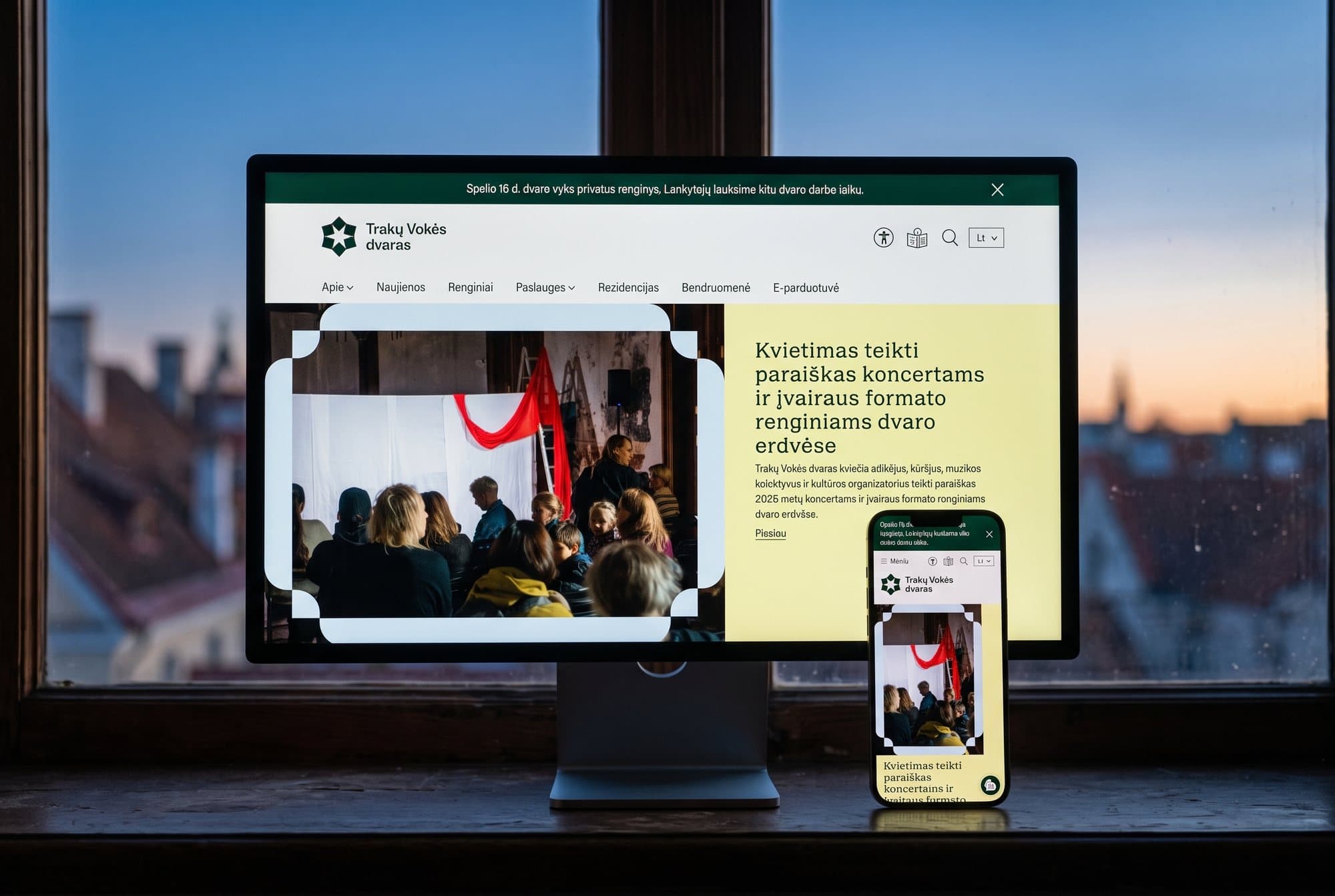 The Trakų Vokės dvaras website on a monitor and a phone